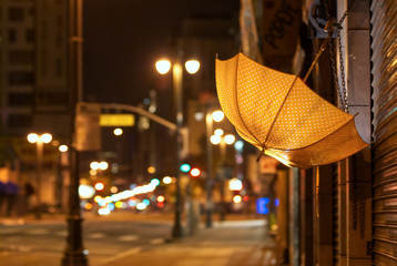 An orange umbrella hanging in the city