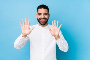 Young latin man against a blue  background isolated showing number ten with hands.