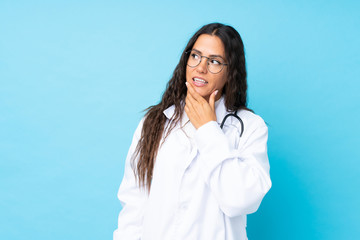 Young doctor woman over isolated blue background thinking an idea