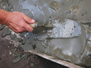 laying a layer of cement with a construction trowel