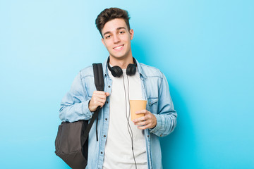 Young caucasian student man holding a take away coffee happy, smiling and cheerful.