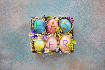 Easter background card with decor eggs in a box and flowers