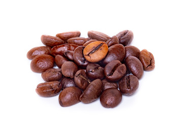 a small pile of roasted coffee beans on a white background. coffee mania.close up.