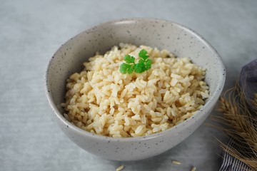 Bowl of cooked Whole grain brown rice  on wooden background overhead view