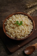 Bowl of cooked Whole grain brown rice  on wooden background overhead view