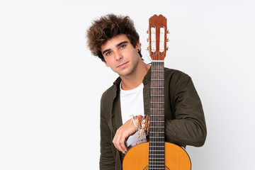 Young caucasian man with guitar over isolated white background