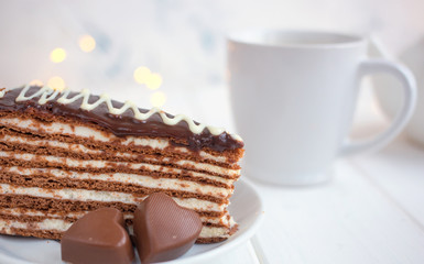 Slice of cake on a saucer and hearts on a white background.