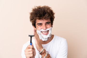 Young handsome man shaving his beard whispering something