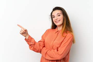 Young brunette girl over isolated white background pointing finger to the side