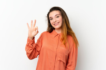 Young brunette girl over isolated white background showing ok sign with fingers