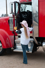 Woman trucxk driver getting into her big truck