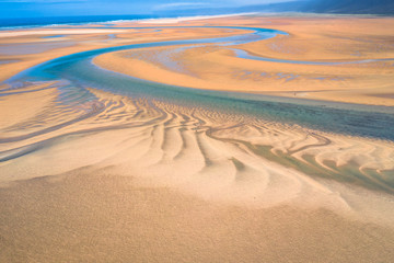 Fototapeta na wymiar Aerial drone view of icelandic Raudasandur beach with azure water streams and yellow sand