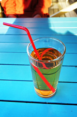Glass of apple juice on the table in summer cafe.