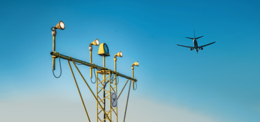 Drone zone sign on approach lighting system at runway. Airport airspace prohibition drones fly sign. Flying plane in background.	