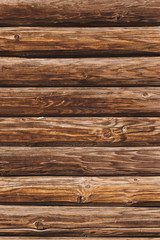 vertical view of natural rough hewn wood log wall showing grain and knots
