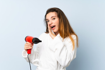 Young woman in a bathrobe with hair hairdryer whispering something