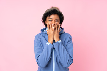 African american woman with winter hat over isolated pink background with surprise facial expression