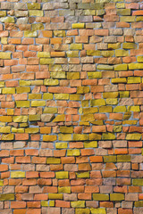 surface of old crumbling abstract decorative mosaic with faded orange and yellow colors as background. Multicolored ceramic stones on wall building