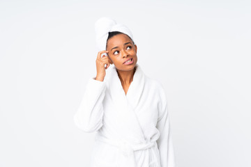 African american woman  in a bathrobe over isolated background having doubts and with confuse face expression