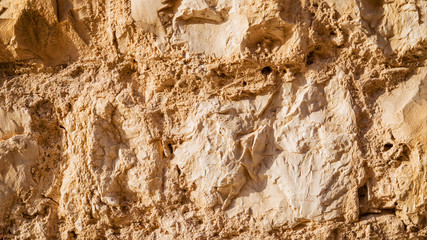 Wall sandstone texture background. Yellow old grunge surface, stone vintage texture. Voluminous background. 16:9 panoramic format