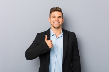 Young handsome caucasian man smiling and raising thumb up