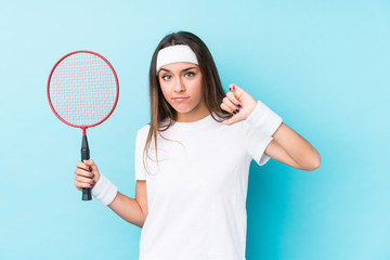 Young caucasic woman playing badminton isolated showing a dislike gesture, thumbs down. Disagreement concept.