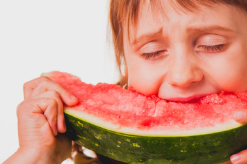 Beautiful child girl eating watermelon against white background. Happiness, joy, holiday concept.