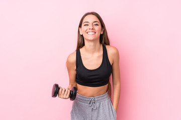 Young caucasian sporty woman holding a dumbbell