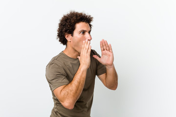 Mature handsome man isolated shouts loud, keeps eyes opened and hands tense.