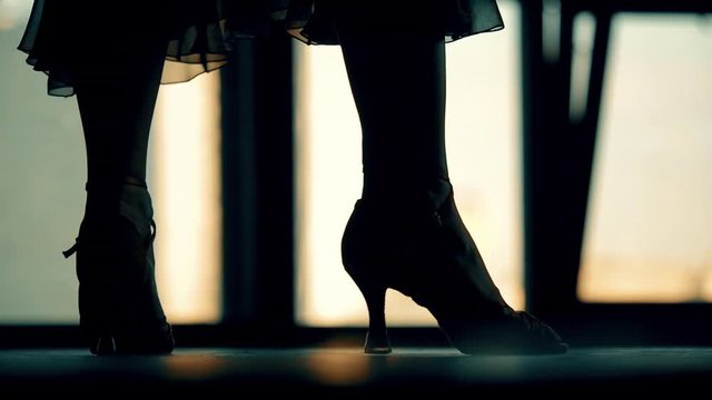 close-up of the legs of a man and a woman dancing a pair of ballroom dance in the room. Dance moves of the tango, Latinos, the Paso Doble. Gait.
