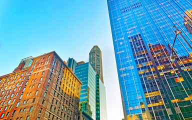 Bottom up Street view on Financial District of Lower Manhattan, New York City, NYC, USA. Skyscrapers tall glass buildings United States of America. Blue sky on background. Empty place for copy space.