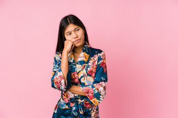 Obraz premium Young asian woman wearing a kimono pajamas who feels sad and pensive, looking at copy space.
