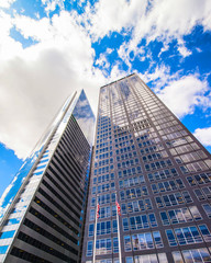 Bottom up Street view on Financial District of Lower Manhattan, New York City, NYC, USA. Skyscrapers tall glass buildings United States of America. Blue sky on background. Empty place for copy space.