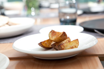 Fried potato wedges on a white plate.