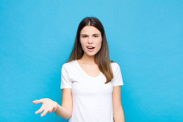 young pretty woman looking angry, annoyed and frustrated screaming wtf or what‚Äôs wrong with...