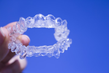 Invisible dental braces held by woman hand