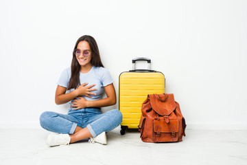 Young mixed race indian woman ready to go to travel laughs happily and has fun keeping hands on stomach.