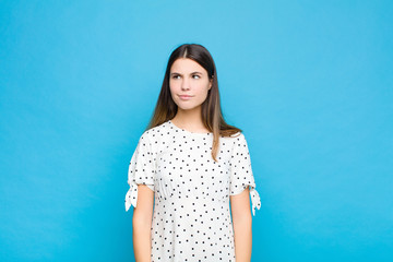 young pretty woman looking puzzled and confused, wondering or trying to solve a problem or thinking...