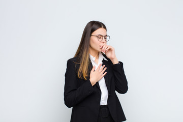 young businesswoman feeling ill with a sore throat and flu symptoms, coughing with mouth covered...