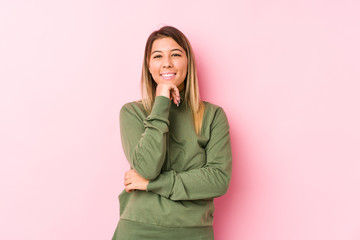 Young caucasian woman posing isolated  smiling happy and confident, touching chin with hand.