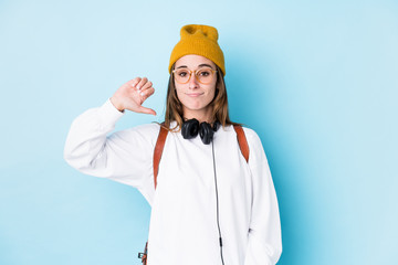 Young caucasian woman with earphones isolated showing a dislike gesture, thumbs down. Disagreement...