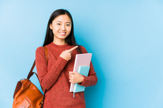 Young Chinese Student Woman Isolated Smiling And Pointing Aside, Showing Something At Blank Space.