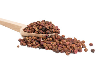 sichuan pepper in wooden spoon isolated on white background. food ingredient.