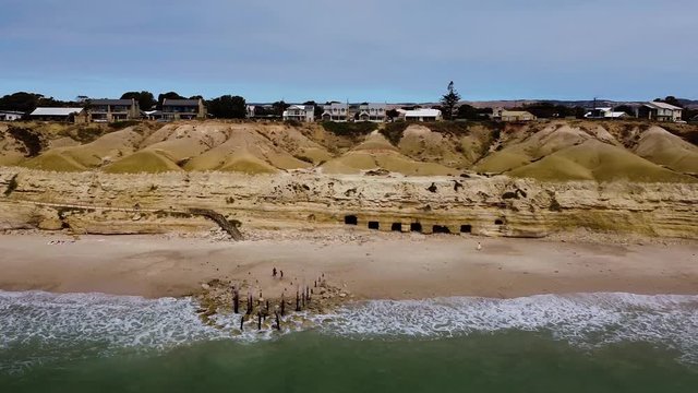 Aerial flying out oversea at Port Willunga caves and ruins