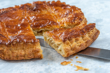Epiphany Twelfth Night cake french galette des rois made of puff pastry, slice apart with the charm inside,