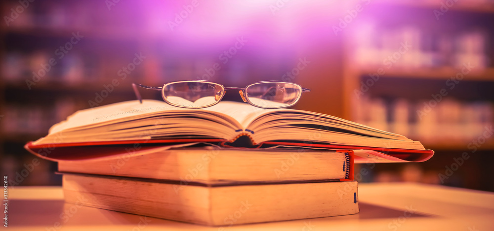 Aufkleber stack of books in the library and blur background