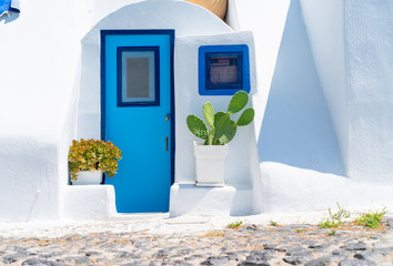 White exterior Mediterranean style entrance with blue door