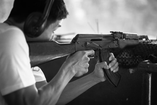 Man aiming a gun at the shooting range, target practicing.