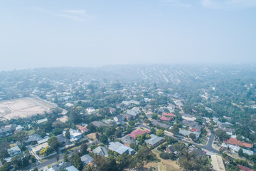 Fototapeta na wymiar Aerial view of homes unders heavy smoke haze from bush fires in Victoria, Australia
