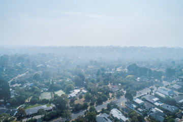 Bushfire smoke haze brought by wind onto suburban areas of Melbourne - aerial view